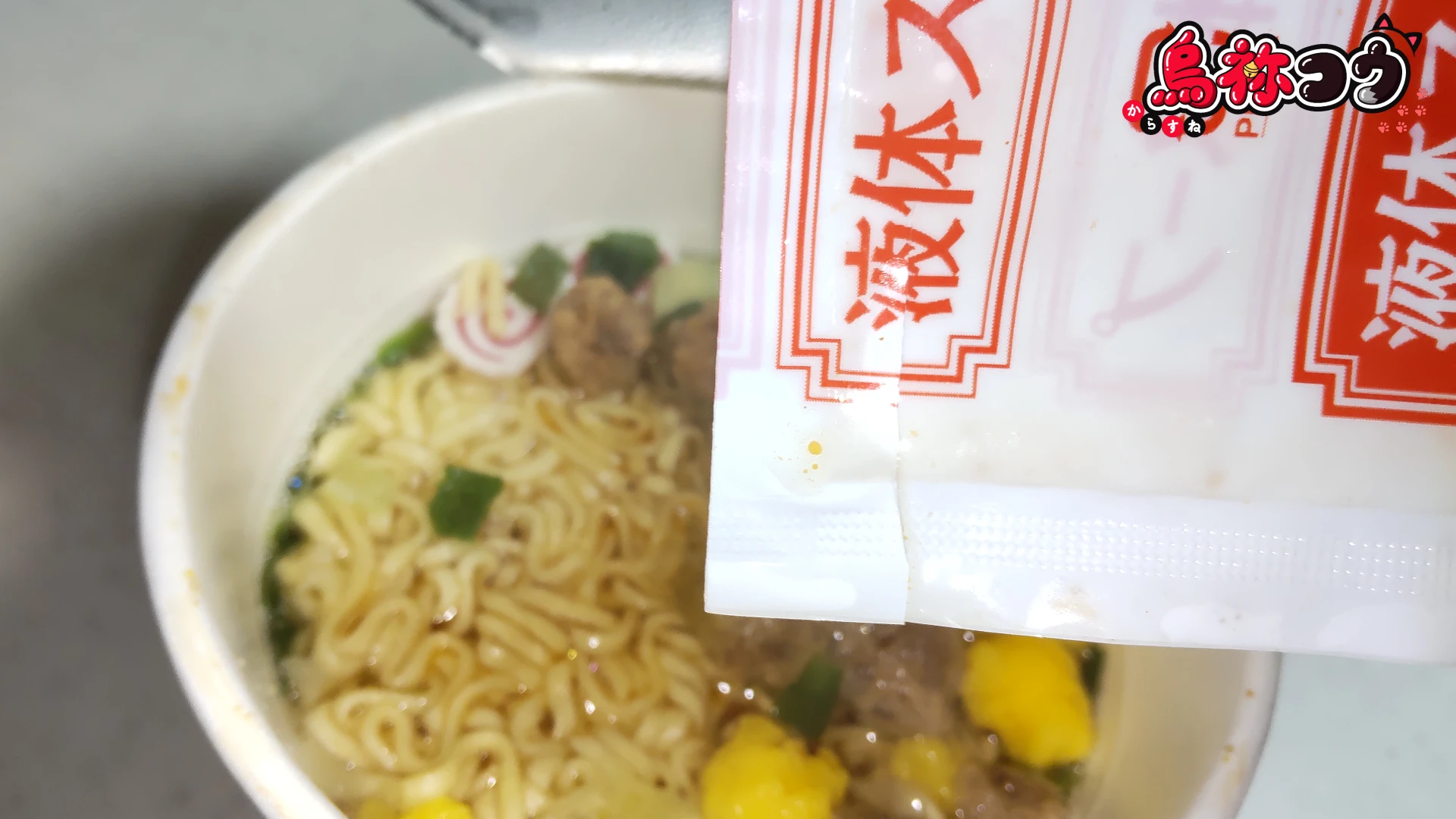 大黒食品の AKAGI 中華そば 縦型カップに液体スープを入れているところです