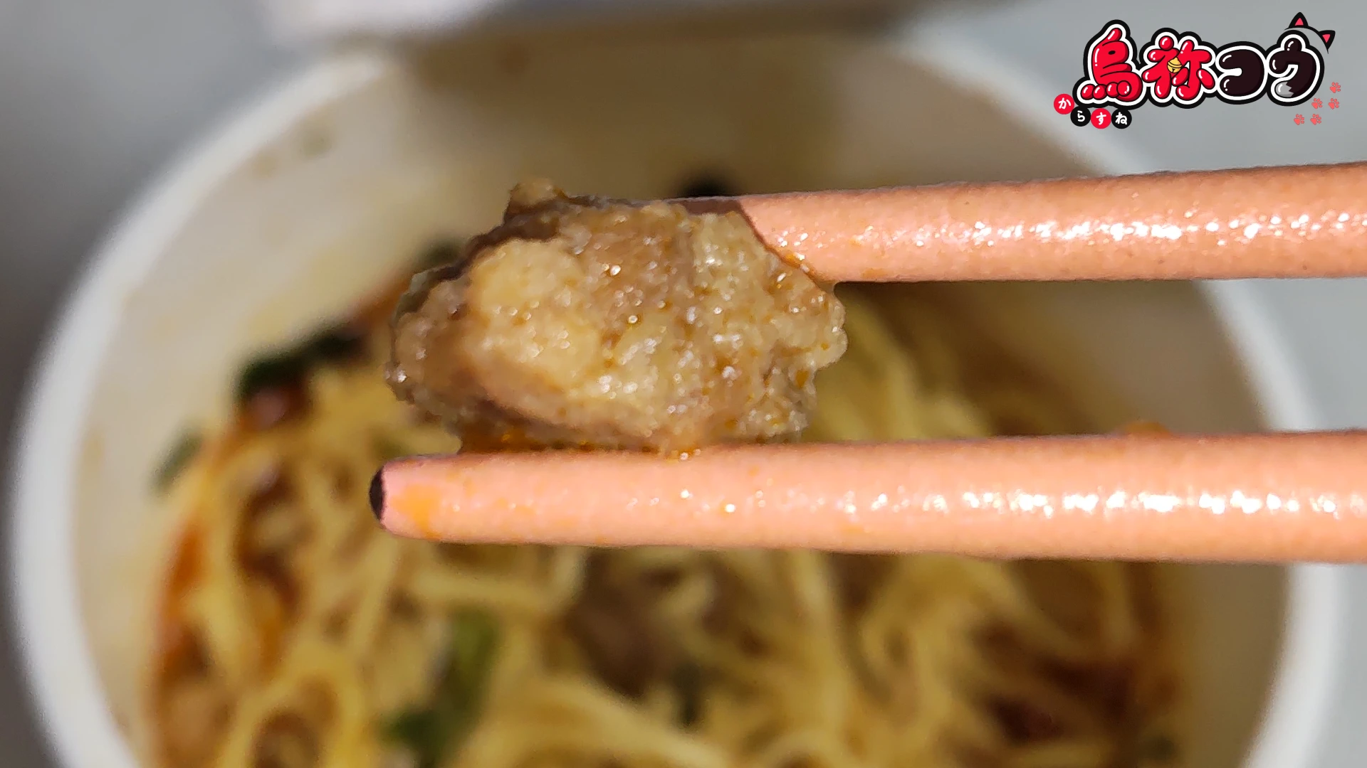 ファミマルの味仙 台湾ラーメンに入っている謎肉を箸でつまんだところです